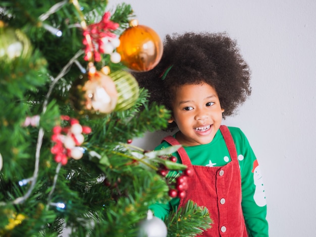 写真 子供はクリスマスツリーでクリスマスを祝うために幸せで面白いです