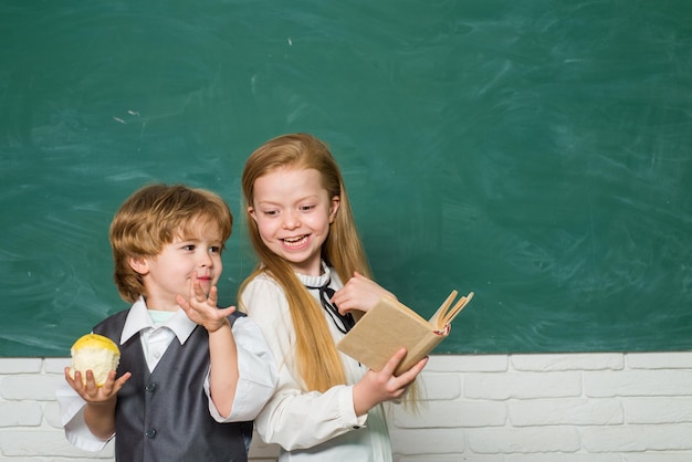 Фото Ребенок учится в классе на фоне школьной доски, милый маленький мальчик дошкольного возраста с