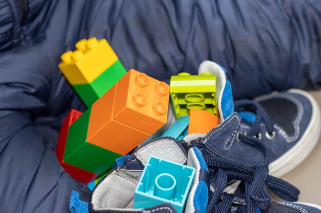 Photo kid is playing with lego toys in a car lego toys in blue shoes for kidsactivities on the road