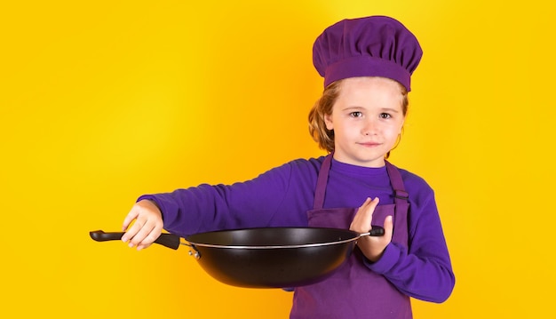 Kid jongen chef kok met kookpan Kid chef kok studio portret Kinderen koken Kid jongen met schort en chef-kok hoed