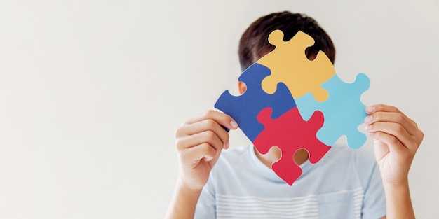 Foto kid jongen handen met puzzel legpuzzel, geestelijke gezondheid concept, wereld autisme bewustzijn dag