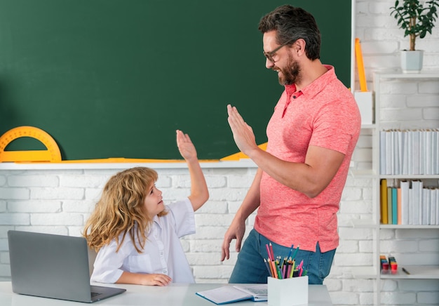 Kid jongen leren met leraar grappige kleine jongen studeren met vader in de klas op schoolbord leerling van pri