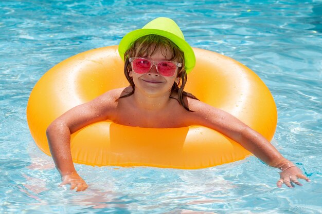 Kid jongen spelen met opblaasbare drijvende ring in zwembad Zomervakantie concept Zomer kinderen portret in zeewater op strand