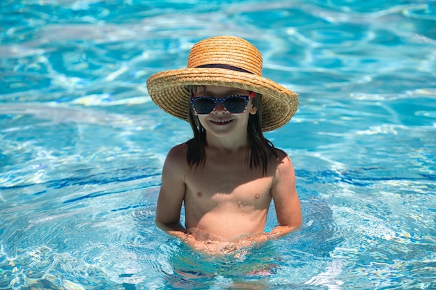 Kid jongen zwemmen in het zwembad zomer en zwemmen activiteiten voor kinderen op het zwembad actieve kid