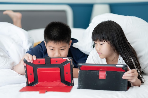 Kid kijken tablet op het bed kind verslaafde cartoon