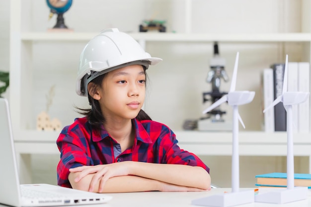 Photo kid learning about renewable energy child girl how wind turbines work