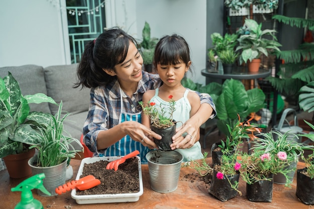 いくつかの植物を植えるガーデニングを行う方法を学ぶ子供