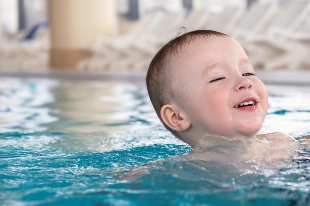 Kid learning to swim in the indoor pool