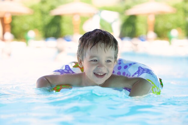 Kid learns to swim using a plastic water ring