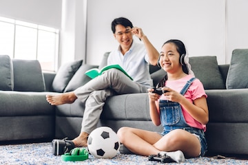 Asian man fun playing video games console with his girlfriend