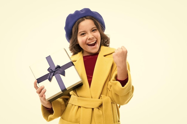 Kid little girl in elegant coat curly hairstyle hold gift box Child excited about unpacking her gift Small cute girl received holiday gift Dreams come true Best birthday and christmas gifts