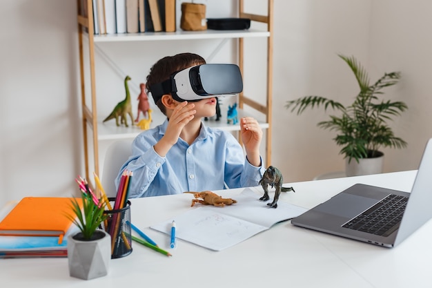 Kid looking virtual reality dinosaurs via VR glasses. Child play 3d video game at home. Learning paleontology with modern technologies. Concept of early childhood education