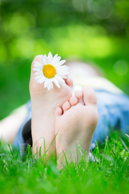 Малыш лежит на траве на открытом воздухе в весеннем парке