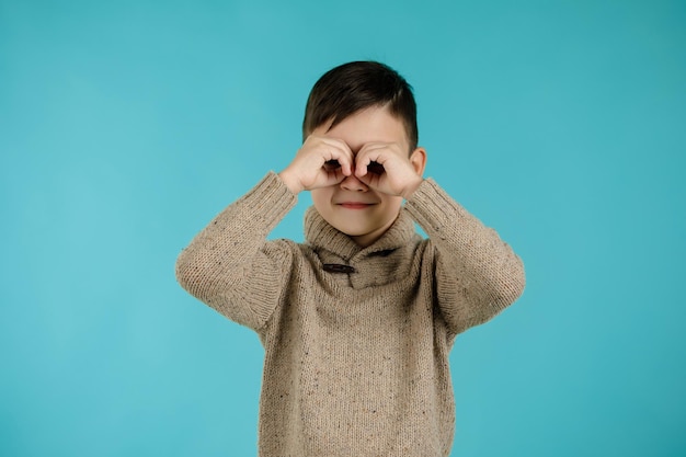 Kid making mask or making gesture like binoculars