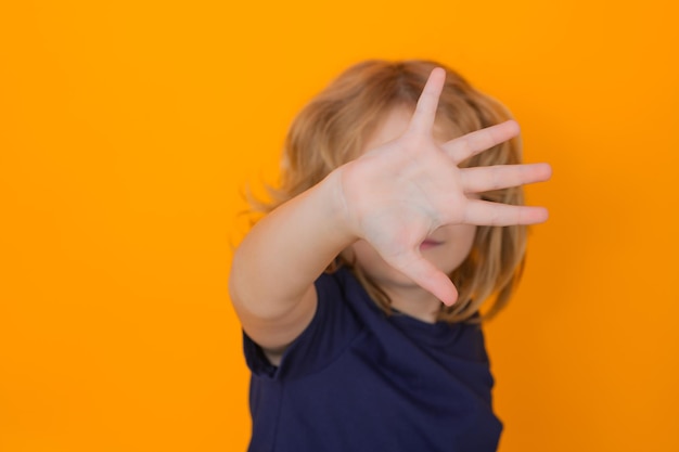 Kid making stop gesture on isolated studio background kid showing warning symbol hand sign no kids p