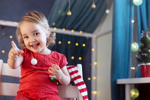 Kid meisje rode pyjama versieren kamer kerst wintervakantie oudejaarsavond