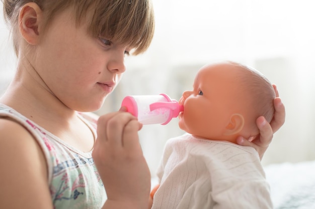 Kid meisje spelen met pop voeden pop fles