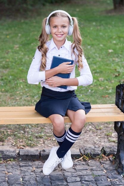 Kid met behulp van moderne technologie. Moderne kind. Perfect geluid. Schattige jongen met draadloze headset. Stereo koptelefoon. Vrije tijd concept. Schoolpauze. Geïnspireerd door muziek. Meisje luisteren muziek moderne gadget.