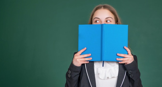 Kid op schoolbord achtergrond verstopt achter werkmap op school