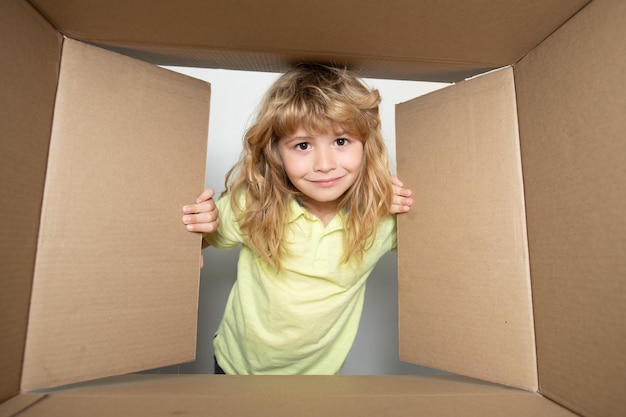 Kid open papieren kartonnen doos vrolijk schattig kind dat een cadeau opent kartonnen dozen pakjes levering