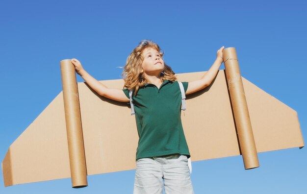 Kid pilot with toy jetpack against sky background Happy child playing outdoors Happy childhood Child