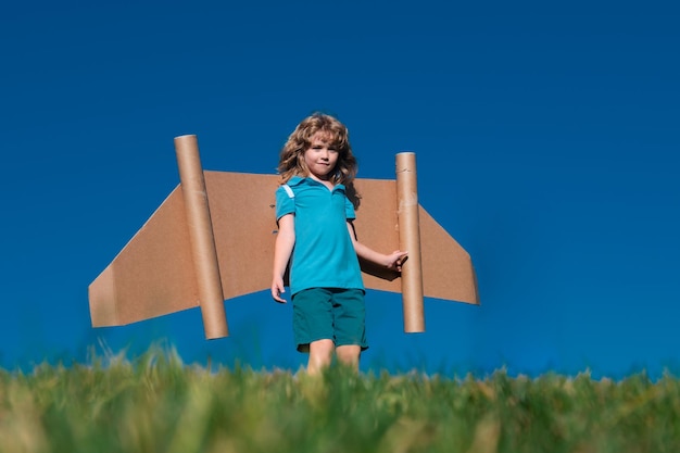 Kid pilot with toy jetpack kid boy play with toy plane cardboard kid dreams of future kid pilot