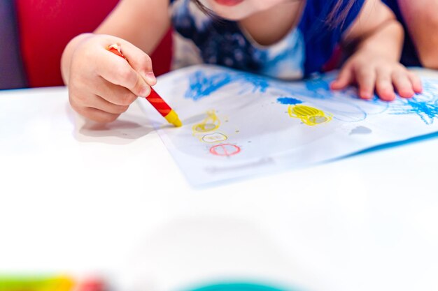 Kid play study and learn how to color and draw the crayon color in to the paper with her parents