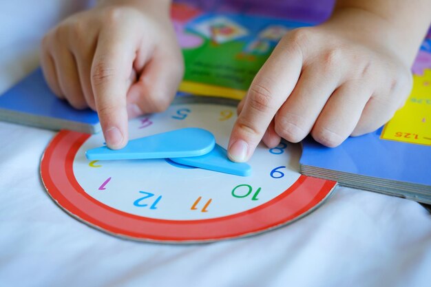 Foto gioca a raccontare il tempo ai bambini piccoli per imparare a leggere un orologio analogico