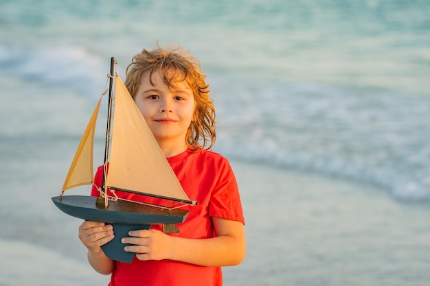 Дети играют с игрушечной парусной лодкой, летние путешествия, детские каникулы, путешествие, путешествие, образ жизни, яхтинг, морское сотрудничество