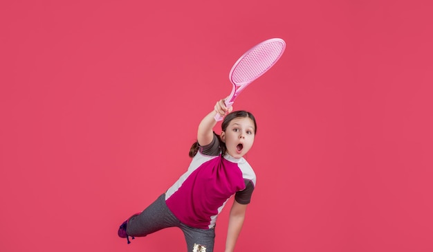 Kid playe tennis with racket on pink background