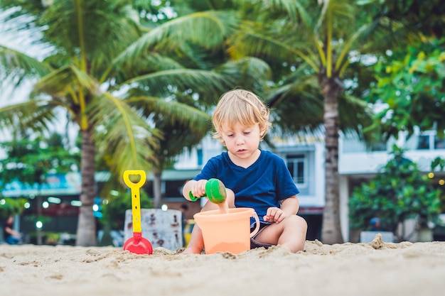 Kid playing on the beach with shovel and a bucket