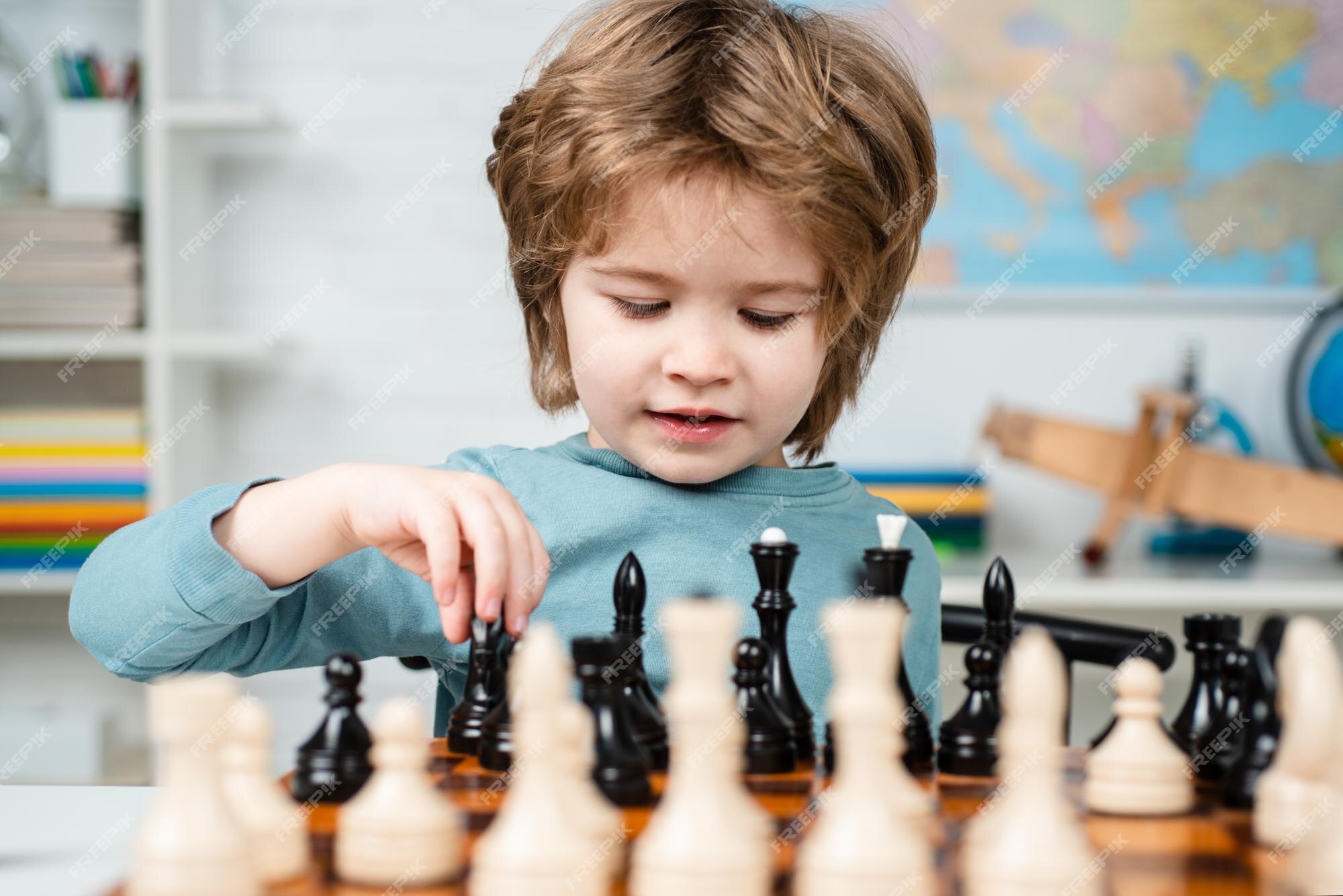 Pupil kid thinking about his next move in a game of chess. Concentrated  little boy sitting at the table and playing chess Stock Photo - Alamy