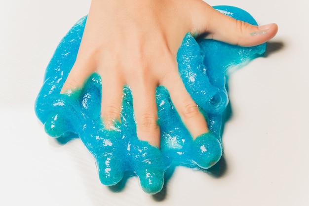 Bambino che gioca a mano toy called slime alien drool shell cozze.