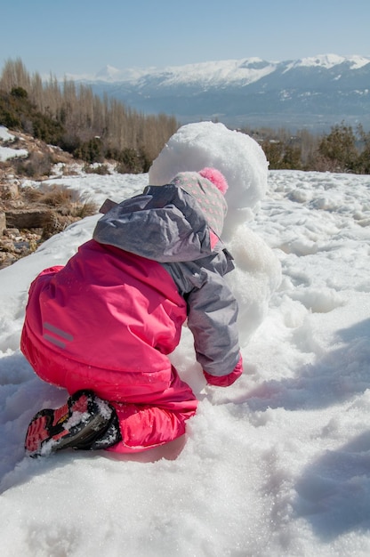 Kid playing in snow. Little girl having fun in beautiful winter park