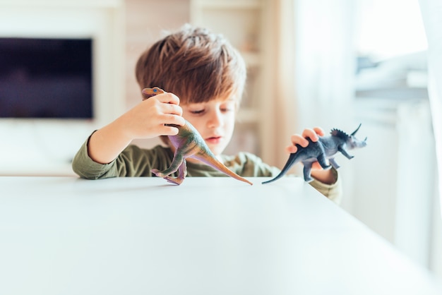 Kid playing with toy dinosaurs