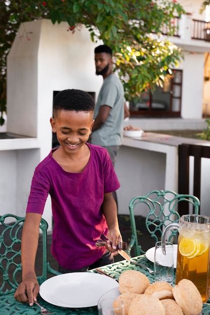 Foto bambino che prepara la tavola da pranzo con il genitore