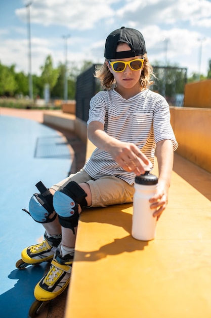 Kid preparing to drink water roller skating