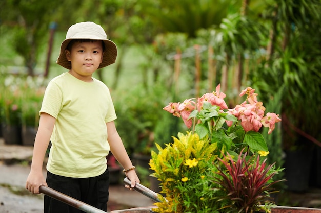 Kid Pushing Wheelbarrow with Flowers