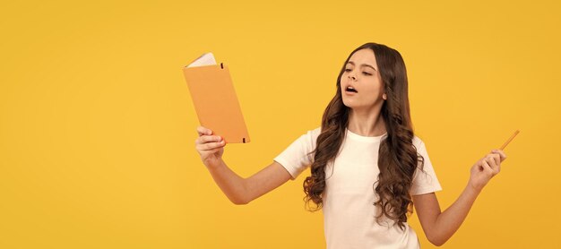 Foto ragazzo che legge studente che si prepara per l'esame scolaressa che fa i compiti a casa rapporto scolastico ritratto di scolaressa studente studio banner intestazione scuola bambino allievo faccia spazio di copia