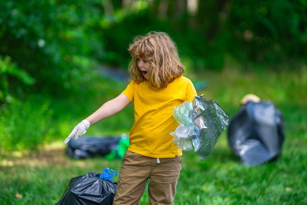 kid in rubber gloves with trash bag clean up garbage on forest outdoor eco environment conservation recycle pollution kid boy collecting garbage and plastic trash save environment eco kids