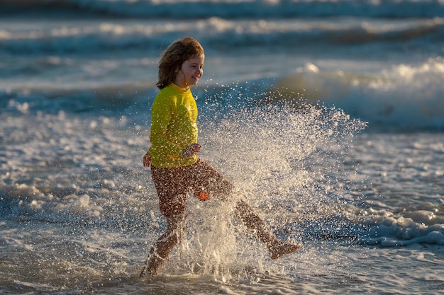 여름 휴가 동안 바닷물에 뛰어드는 아이 바다를 따라 달리는 아이 소년 여름 해변에서 아이