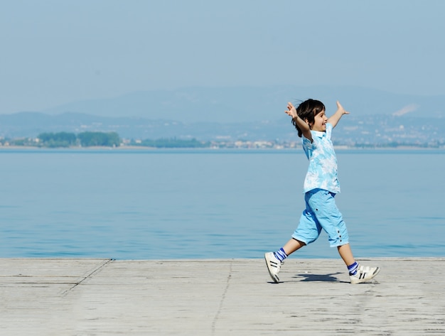 Kid running on lake dock