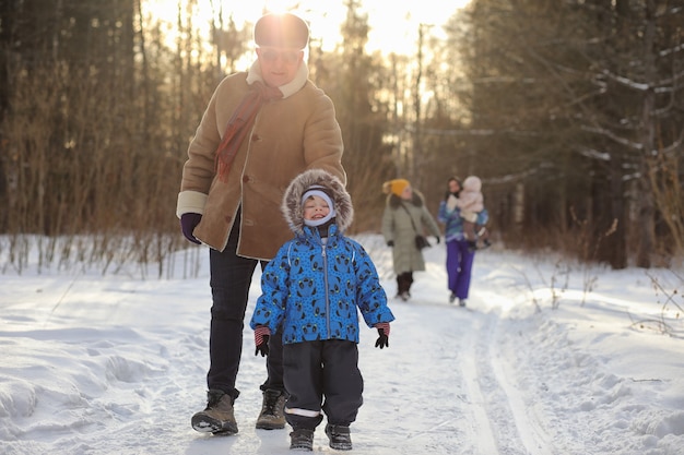 Kid running in a winter park and have fun with family