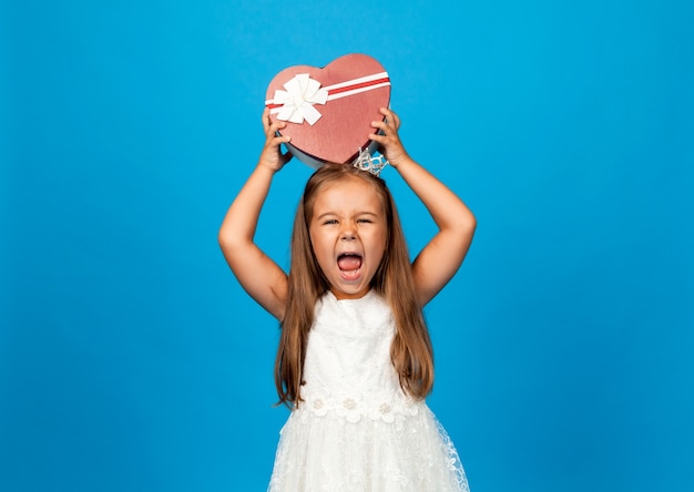 子供の誕生日プレゼント。サプライズとギフトボックス。贈り物の箱を持っている少女。