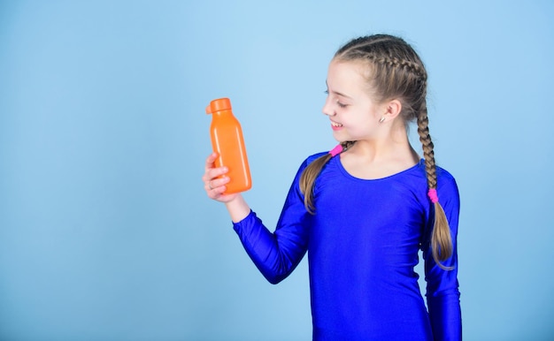 Kid schattig meisje gymnast sport turnpakje houd fles voor drinken Waterbalans en harde gym training Drink meer water Houd een waterfles bij je Les dorst Kind voelt dorst na sporttraining