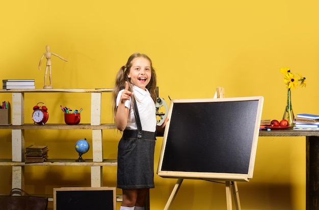 Kid and school supplies on yellow background