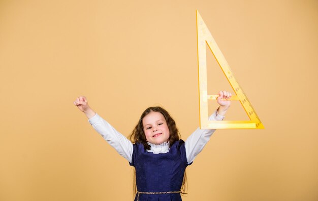 Kid schooluniform houd heerser School onderwijs concept Leer wiskunde Stellingen en axioma's Slim en slim concept Maatvoering en meten Meisje met grote liniaal School student studie geometrie