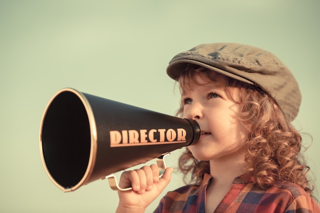 Kid shouting through vintage megaphone. Communication concept. Retro style