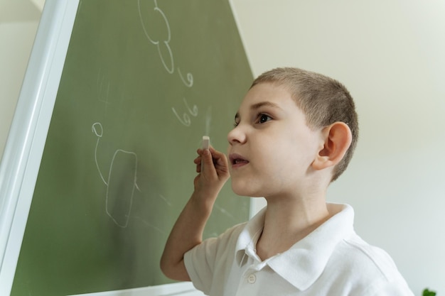 Foto il bambino mostra e spiega il modello del generatore eolico e il disegno sul progetto educativo del consiglio scolastico