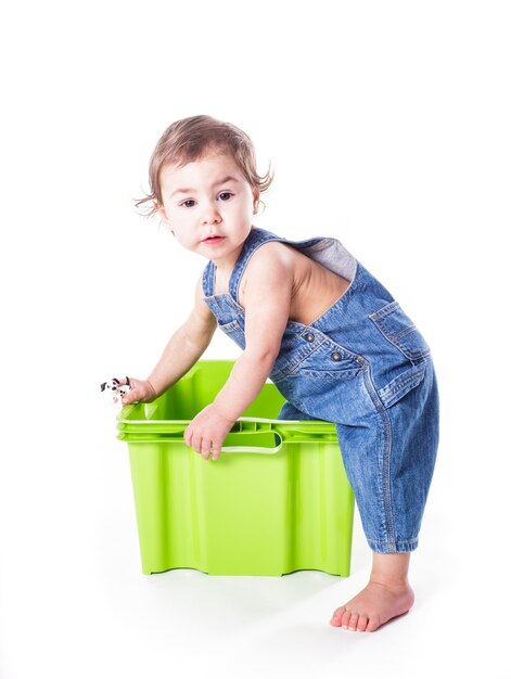 Kid speelt met plastic container geïsoleerd op wit